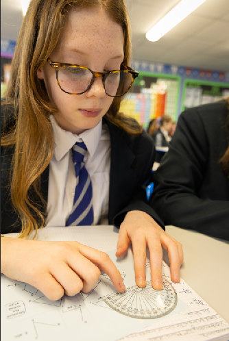 pupil completing maths work and using a potractor